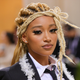 Amandla Stenberg with blonde, braided hair and a black jacket at the 2021 Met Gala.